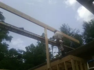 Carpenter setting a ridge beam over a new addition frame — Ice Dam Removal by Roofing Brothers in Glendora